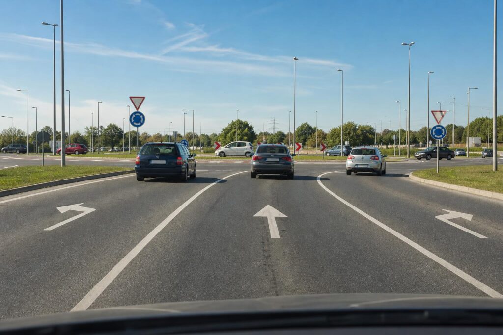 Többsávos körforgalom jól látható sávnyilakkal és szabályosan haladó autókkal