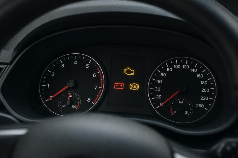 Autó műszerfala felvillanó motorhiba-, ABS- és akkumulátor-visszajelzőkkel