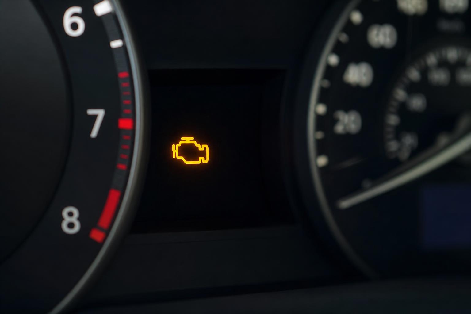 Autó műszerfala világító motorhiba-jelző lámpával, vezérműlánc-probléma gyanújára utaló hibajelzésként