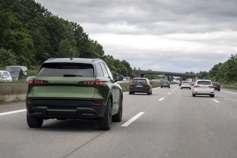 Zöld SUV német autópályán több szürke, fekete és fehér autó között