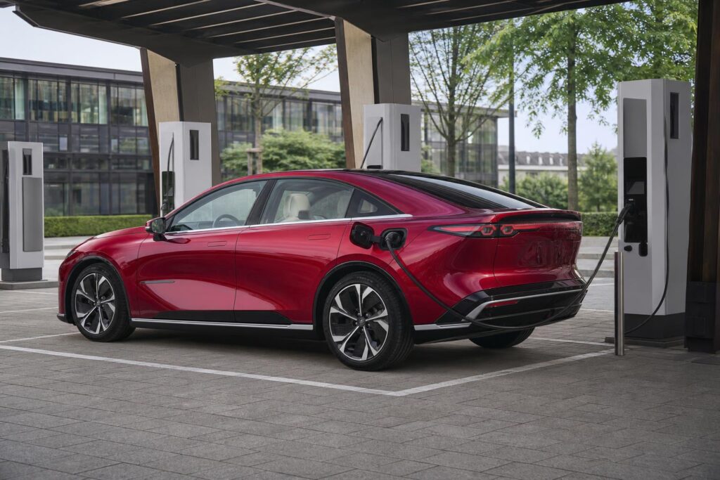 Piros Mazda 6e elektromos limuzin töltőállomáson